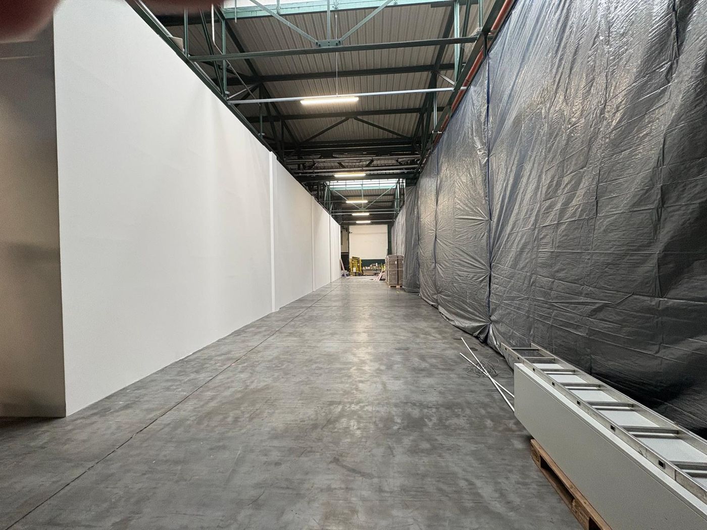 Dokončená chodba vestavby v pivovaru Radegast — bílé stěny a průmyslový prostor